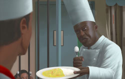  1girl 2boys black_eyes chef_hat chef cindy_(commando) commando_(movie) commentary cooke_(commando) curry curry_rice dark-skinned_male dark_skin food hansodeya hat head_tilt holding holding_food holding_spoon iron_bars john_matrix male_focus multiple_boys plate pun realistic rice spoon teeth upper_body 