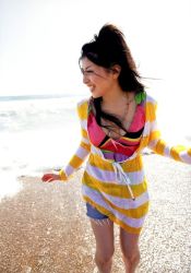  1girl beach black_hair breasts brown_eyes chihara_minori colorful jewelry long_hair necklace ocean outdoors photo_(medium) sand voice_actor shorts smile striped teeth water 
