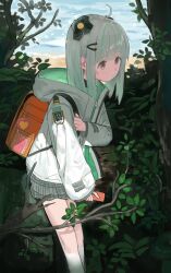 1girl absurdres admi_(nikke) ahoge backpack bag bag_charm branch bush cellphone charm_(object) crime_prevention_buzzer goddess_of_victory:_nikke gradient_hair green_hair grey_hair grey_skirt hair_ornament headgear highres holding holding_phone holding_strap hood hood_down hooded_jacket jacket kneehighs looking_down multicolored_hair outdoors peparonipi20 phone pink_eyes plaid_clothes plaid_skirt pleated_skirt randoseru sand skirt smartphone socks standing streaked_hair tree two-sided_fabric two-sided_jacket water white_jacket white_socks