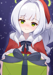 1girl blue_archive blush capelet closed_mouth commentary_request fur-trimmed_capelet fur-trimmed_headwear fur_trim gift green_eyes green_halo hair_intakes halo hare_(blue_archive) hat highres holding holding_gift looking_at_viewer pom_pom_(clothes) red_capelet red_hat santa_hat signature smile solo tawashi_(hoisassa) white_hair
