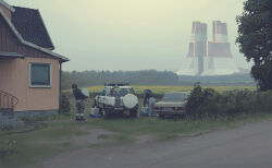 Rule 34 | absurdres, architecture, boots, building, cable, car, cloud, cloudy sky, crt, day, denim, grass, highres, holding, honda cr-v, house, jacket, jeans, medium hair, motor vehicle, outdoors, pants, plant, scenery, science fiction, simon stalenhag, sky, spare tire, stairs, standing, swedish machines, track jacket, tree, unused tire, wheel, window