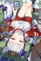 1girl animal_ears bag black_socks blurry blurry_background blush bow breasts brown_hat cellphone commentary_request ear_bow food food_in_mouth gold_ship_(umamusume) hand_in_pocket hat highres holding holding_phone horse_ears horse_girl horse_tail indoors jacket komeko97 long_sleeves looking_at_viewer lying medium_breasts on_back open_clothes open_jacket phone pillbox_hat plant popsicle popsicle_in_mouth potted_plant purple_bow rubik&#039;s_cube school_bag school_uniform shirt smartphone snack socks solo_focus tail tracen_school_uniform track_jacket umamusume white_shirt yellow_eyes