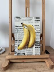 absurdres art_tools_in_frame banana easel food food_focus fruit highres julia_stankevych newspaper no_humans oil_painting_(medium) original painting_(medium) photo_(medium) realistic signature still_life table traditional_media wall_of_text wooden_table