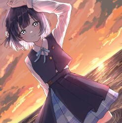 1girl arm_up black_overskirt black_vest blue_ribbon blue_skirt blunt_bangs blush commentary dutch_angle floating_hair gakuen_idolmaster hataya_misuzu hatsuboshi_gakuen_school_uniform highres horizon idolmaster long_sleeves looking_at_viewer mole mole_under_mouth neck_ribbon outdoors pleated_skirt purple_hair ribbon rinsu_(kilakira13) school_uniform shirt short_hair skirt smile solo sunset symbol-only_commentary vest wading white_shirt
