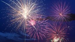 aerial_fireworks blue_sky fireworks highres light_particles mountain night no_humans non-web_source official_art our_life:_beginnings_and_always outdoors scenery sky water
