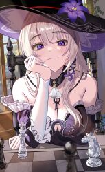 1girl absurdres arm_under_breasts ascot bare_shoulders black_sleeves blurry blurry_foreground breasts brown_hair chess_piece chessboard cleavage commentary_request detached_sleeves flower hat hat_flower herta_(honkai:_star_rail) highres honkai:_star_rail honkai_(series) indoors jewelry key key_necklace large_breasts long_hair looking_at_viewer necklace purple_eyes purple_flower rererere_mon sitting smug solo sunlight table the_herta_(honkai:_star_rail) white_ascot witch_hat