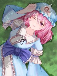 1girl arm_up blue_hat blue_kimono blush bow chinese_commentary closed_mouth commentary_request dappled_sunlight day frilled_bow frilled_kimono frills grass hair_between_eyes hat highres japanese_clothes kimono looking_at_viewer medium_hair mob_cap on_grass on_ground one_eye_closed outdoors pink_eyes pink_hair purple_bow ribbon-trimmed_bow ribbon_trim saigyouji_yuyuko sleeve_garter solo sunlight touhou triangular_headpiece xiangqian680