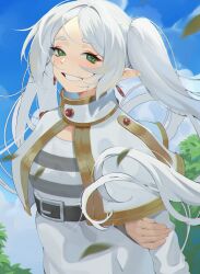1girl arms_behind_back belt capelet clenched_teeth commentary day dress earrings elf floating_earrings frieren green_eyes highres holding_own_arm jewelry leaf long_hair long_sleeves looking_at_viewer outdoors pointy_ears pokoporoko sky smile solo sousou_no_frieren teardrop_earrings teeth twintails white_capelet white_dress white_hair
