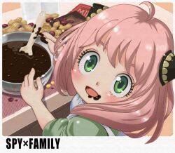 1girl anya_(spy_x_family) apron border bowl child chocolate chocolate_making chocolate_on_face chocolate_on_hand commentary cooking copyright_name food food_on_face food_on_hand green_eyes green_shirt hairpods indoors kainan looking_at_viewer looking_back mixing_bowl peanut pink_hair shirt sleeves_rolled_up solo spoon spy_x_family valentine white_apron white_border wooden_spoon