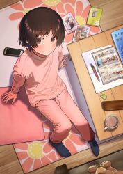 Rule 34 | 1girl, arm support, black socks, blush, brown eyes, brown hair, cellphone, cup, cushion, eraser, floral print, from above, highres, looking at viewer, loungewear, manga (object), mechanical pencil, mug, original, pants, pencil, phone, pink pants, pink shirt, rug, shirt, smartphone, socks, solo, stuffed animal, stuffed toy, table, teddy bear, toraneko