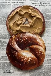 absurdres acrylic_paint_(medium) bagel food food_focus highres impasto julia_stankevych newspaper no_humans oil_painting_(medium) original painting_(medium) peanut_butter photo_(medium) realistic sesame_seeds signature still_life traditional_media wall_of_text