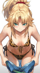 1girl animal_print bare_shoulders bikini blonde_hair blush braid breasts clothes_pull collarbone fate/apocrypha fate_(series) front-tie_bikini_top front-tie_top green_eyes hair_ornament hair_scrunchie half_up_braid highres jewelry leopard leopard_print long_hair looking_down medium_breasts mordred_(fate) necklace pants pants_pull ponytail red_scrunchie scrunchie side-tie_bikini_bottom sidelocks solo swimsuit tonee