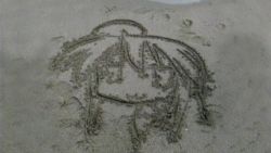 00s 1girl :3 ahoge beans female_focus from_above izumi_konata lucky_star outdoors sand sand_art solo unconventional_media