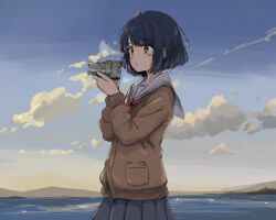 1girl black_hair blue_sky bob_cut brown_cardigan brown_eyes camera cardigan cloud commentary_request day holding holding_camera long_sleeves mountainous_horizon neckerchief ocean original outdoors red_neckerchief sailor_collar school_uniform serafuku shimkarom sky solo standing white_sailor_collar