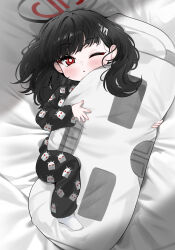 1girl absurdres aged_down alternate_costume bed_sheet black_hair black_halo black_pajamas blue_archive blush bright_pupils hair_ornament hairclip halo highres hugging_object long_hair looking_at_viewer lying multicolored_halo no_shoes on_back one_eye_closed pajamas parted_lips pillow print_pajamas red_eyes red_halo ringed_eyes rio_(blue_archive) socks solo two-tone_halo white_pupils white_socks yuki_(asayuki101)