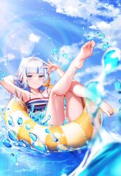 1girl ahoge arm_up armpits barefoot bikini blue_eyes blue_nails blue_sky blunt_bangs blurry blurry_foreground blush closed_mouth cloud cloudy_sky collarbone commentary day ebi-chan_(gawr_gura) english_commentary feet fins fish_tail flat_chest frills gawr_gura grey_hair hand_up highres holding hololive hololive_english innertube knee_up koukie leg_up legs lens_flare long_hair looking_at_viewer multicolored_hair nail_polish outdoors shark_girl shark_tail shiny_skin shrimp sky smile soles solo streaked_hair striped_bikini striped_clothes swim_ring swimsuit tail toenail_polish toenails toes virtual_youtuber water
