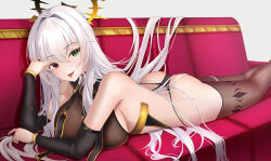 1girl ass bare_shoulders bikini breasts brown_bikini brown_thighhighs closed_mouth couch detached_collar detached_sleeves gold_trim green_eyes halo hand_up heterochromia highres large_breasts long_hair long_sleeves looking_at_viewer lying mole mole_under_eye on_couch on_stomach original raurashun red_eyes smile solo string_bikini swimsuit thighhighs tongue tongue_out very_long_hair white_hair