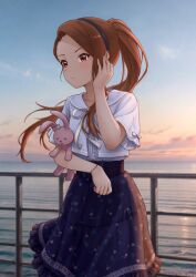 1girl black_hairband blue_skirt brown_eyes brown_hair dress_shirt floating_hair ganyo226 hairband highres idolmaster idolmaster_(classic) long_hair medium_skirt minase_iori neck_ribbon outdoors ponytail print_skirt ribbon shirt short_sleeves skirt solo stuffed_animal stuffed_rabbit stuffed_toy sunrise very_long_hair white_ribbon white_shirt