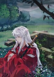 1boy animal_ears bead_necklace beads blurry blurry_foreground crossed_arms dog_boy dog_ears feet_out_of_frame grass hair_between_eyes hakama highres holding holding_sword holding_weapon inuyasha japanese_clothes jewelry katana long_hair male_focus necklace outdoors rain red_hakama red_shirt shirt sidelocks sitting solo sword tooth_necklace tree weapon well wet white_hair xue_ezi yellow_eyes