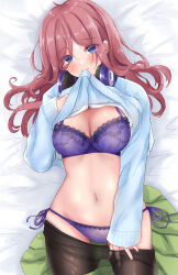 1girl ayachanman black_pantyhose blue_eyes blue_sweater bra breasts brown_hair clothes_in_mouth clothes_lift clothes_pull commentary_request go-toubun_no_hanayome green_skirt headphones headphones_around_neck highres large_breasts lifting_own_clothes long_hair lying nakano_miku navel on_back on_bed panties pantyhose pantyhose_pull purple_bra purple_panties side-tie_panties skirt solo stomach sweater sweater_lift underwear unworn_skirt