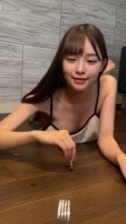 1girl animated asian breasts brown_hair downblouse fork happy highres indoors jiggle long_hair looking_at_viewer lying medium_breasts no_bra on_stomach open_mouth pjms_miku real_life smile solo sound tagme teeth video