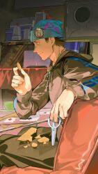 1boy absurdres ace_attorney apollo_justice:_ace_attorney badge beanie beard_stubble blue_hat brown_hair button_badge card closed_mouth couch facial_hair grey_hoodie hand_up hat highres holding holding_scissors hood hoodie male_focus omurice_(304975636) on_couch pants phoenix_wright playing_card profile scissors short_hair sitting solo stubble