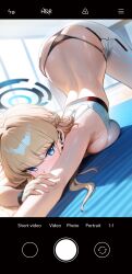 1girl black_panties blonde_hair blue_archive blue_eyes blush breast_press breasts camera_ui dondonai eyelashes female_focus halo indoors large_breasts long_hair looking_at_viewer lying on_stomach panties pants selfie shiny_skin solo sweat thong toki_(blue_archive) top-down_bottom-up underwear user_interface white_pants
