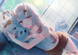 1girl :3 blurry blurry_background center-flap_bangs chihiro_ayaka closed_mouth commentary_request copyright_notice day dolphin_shorts fang gradient_hair grey_hair hair_between_horns hololive horns indoors long_hair looking_at_viewer lying midriff multicolored_hair nakiri_ayame official_art on_floor on_side oni poyoyo_(nakiri_ayame) red_eyes red_hair red_shorts shirt short_shorts shorts skin-covered_horns skin_fang smile solo streaked_hair t-shirt virtual_youtuber white_shirt