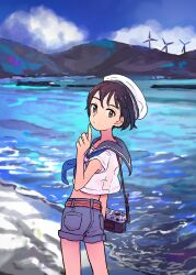 1girl black_hair blue_sailor_collar blue_shorts blue_sky brown_eyes camera closed_mouth cloud commentary_request cowboy_shot day denim denim_shorts hand_up hat highres looking_at_viewer looking_back mountainous_horizon neckerchief ocean original outdoors sailor_collar sailor_hat shirt short_hair short_shorts short_sleeves shorts sky solo standing takaichi_(tkch) water white_shirt wind_turbine windmill