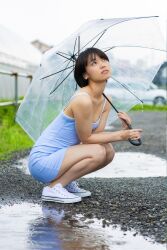 1girl black_hair blue_dress blurry blurry_background collarbone dress flat_chest japanese_(nationality) looking_up monami_suzu outdoors photo_(medium) shoes short_hair sneakers umbrella water