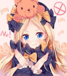 1girl :t abigail_williams_(fate) black_bow black_dress black_hat blonde_hair blue_eyes blush bow candy_wrapper closed_mouth commentary_request dress fate/grand_order fate_(series) female_focus forehead hair_bow hands_up hat long_hair long_sleeves nahaki no on_head orange_bow parted_bangs polka_dot polka_dot_bow pout sleeves_past_wrists solo stuffed_animal stuffed_toy teddy_bear v-shaped_eyebrows very_long_hair x_arms