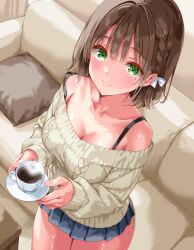 1girl absurdres bare_shoulders black_skirt braid breasts brown_hair brown_sweater cleavage closed_mouth collarbone couch cowboy_shot cup green_eyes highres holding holding_cup iwato_(celler) looking_at_viewer medium_breasts medium_hair miniskirt missing_commentary mole mole_under_eye off-shoulder_sweater off_shoulder original pleated_skirt skirt smile solo strap_slip sweater teacup