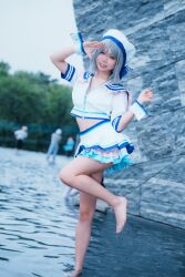 1girl blue_eyes brown_hair cosplay cosplay_photo feet grey_hair love_live! love_live!_sunshine!! photo_(medium) real_life short_hair skirt smile solo standing thighs watanabe_you water
