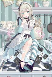 1girl alice_in_wonderland apron aqua_dress aqua_eyes bandaid bandaid_on_knee bandaid_on_leg black_footwear blonde_hair blush book breasts dress finger_to_mouth floating_card frilled_apron frills frying_pan gradient_hair hair_ornament hairband hairclip highres indoors long_sleeves looking_at_viewer medium_breasts multicolored_hair open_book picture_frame pink_hair single_thighhigh sitting solo spatula thighhighs tina_oekaki twintails white_apron