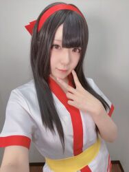 Rule 34 | 1girl, ainu clothes, asian, black hair, breasts, brown eyes, cosplay, hair ribbon, highres, japanese (nationality), long hair, looking at viewer, nakoruru, pink lips, ribbon, samurai spirits, small breasts, smile, snk, solo, the king of fighters, v