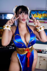 1girl alternate_color alternate_costume blue_dress bracelet braid breasts capcom chilean_(nationality) chun-li chun-li_(cosplay) cleavage cosplay curvy dress highres indoors interior jewelry large_breasts long_hair looking_to_the_side missyle_fg official_alternate_costume parted_lips photo_(medium) real_life revealing_clothes shiny_clothes shiny_skin short_dress simple_background skin_tight smile spiked_bracelet spikes standing street_fighter street_fighter_iv_(series) street_fighter_v thick_thighs thighs v very_long_hair wide_hips