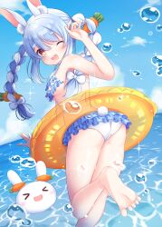 1girl animal_ear_fluff animal_ears barefoot bikini blue_hair breasts carrot_hair_ornament food-themed_hair_ornament hair_ornament hajime_yo highres hololive long_hair looking_at_viewer looking_back ocean open_mouth rabbit_ears ruffle_bikini solo sparkle swimsuit underboob usada_pekora virtual_youtuber water_drop yellow_innertube