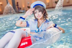 Rule 34 | 1girl, blue eyes, blurry, blurry background, cosplay, cosplay photo, costume, grey hair, hat, indoors, japanese (nationality), looking at viewer, love live!, love live! sunshine!!, mi yan 0728, open clothes, photo (medium), pool, salute, short hair, skirt, solo, swim ring, thighhighs, watanabe you