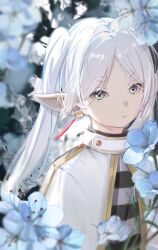 1girl absurdres blue_flower capelet earrings floral_background flower frieren green_eyes highres jewelry long_hair looking_at_viewer outdoors oyaji_hime parted_lips pointy_ears short_eyebrows sidelocks solo sousou_no_frieren thick_eyebrows upper_body white_capelet white_hair
