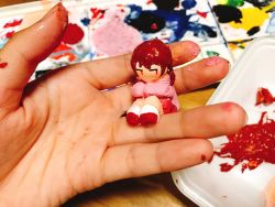 1girl braid brown_hair clay commentary_request female_focus highres holding long_sleeves looking_to_the_side madotsuki outo_eguchi paint painting_(medium) pink_shirt red_eyes red_footwear sculpture shirt sitting socks solo traditional_media twin_braids unconventional_media white_socks yume_nikki