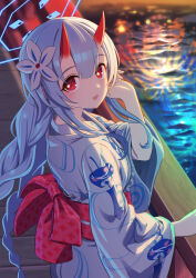 1girl alternate_costume blue_archive blue_hair blue_halo blue_kimono braid bridge chise_(blue_archive) commentary commentary_request english_commentary fireworks flower gradient_horns hair_flower hair_ornament halo hand_on_railing hand_up highres horns japanese_clothes kimono light_blush long_hair looking_at_viewer looking_to_the_side low_twin_braids mixed-language_commentary multicolored_horns night obi oni open_mouth outdoors print_kimono railing red_eyes red_horns reflection reflective_water sash shrimp1634 skin-covered_horns smile solo twin_braids water yukata