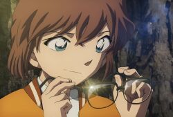 1girl anime_screenshot aoyama_goushou black-framed_eyewear brown_hair close-up closed_mouth crossed_bangs glint green_eyes haibara_ai highres holding holding_removed_eyewear jacket lens_flare light_smile looking_at_object meitantei_conan meitantei_conan_kurogane_no_submarine official_art orange_jacket outdoors portrait rock shirt short_hair solo unworn_eyewear wavy_hair weeds white_shirt