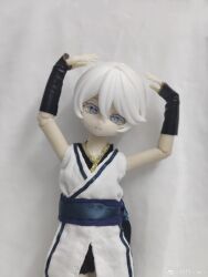 1girl absurdres bare_shoulders belt black_bracer black_shorts bracer chinese_clothes colored_eyelashes doll doll_joints dress figure grey_eyes highres joints ling_yue_w photo_(medium) realistic short_hair shorts simple_background tomboy upper_body vocaloid vsinger_(vocaloid) watermark weibo_username weibo_watermark white_dress white_eyelashes white_hair yanhe yanhe_(daojianchunqiu)