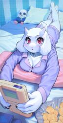 1girl animal_ears bed blush breasts character_doll chips_(food) cleavage fingernails food furry furry_female goat_ears goat_girl goat_horns goat_tail handheld_game_console highres horns inuki_(aruurara) large_breasts looking_at_viewer lying medium_breasts on_stomach open_mouth pajamas pillow potato_chips purple_pajamas red_eyes sans_(undertale) sharp_fingernails shorts solo toriel undertale