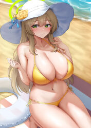 1girl absurdres beach beach_towel bikini blonde_hair blue_archive breasts cleavage closed_mouth collarbone commentary_request day erorange flower green_eyes hair_ornament hat hat_flower highres innertube large_breasts long_hair navel nonomi_(blue_archive) nonomi_(swimsuit)_(blue_archive) ocean official_alternate_costume outdoors sand sidelocks smile solo sun_hat swim_ring swimsuit towel white_hat yellow_bikini yellow_flower