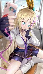 1girl :p absurdres bike_shorts blonde_hair blue_eyes desk heaven_burns_red highres holding holding_phone kanzaki_adelheid lilyhoney on_desk phone satsuki_mari selfie sitting skirt tongue tongue_out v