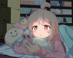 ahoge book bookshelf box brown_eyes cardboard_box cellphone cellphone_charm charm_(object) cruvie hair_between_eyes highres holding holding_phone holding_pillow lying multicolored_hair night on_stomach onii-chan_wa_oshimai! oyama_mahiro phone pillow pink_hair smartphone stuffed_animal stuffed_toy two-tone_hair under_covers