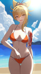 1girl absurdres arm_tattoo beach bikini blonde_hair blush breasts genshin_impact gluteal_fold halterneck highres ituka_kanau looking_at_viewer medium_breasts navel open_mouth orange_bikini outdoors smile solo string_bikini swimsuit tattoo yellow_eyes yoimiya_(genshin_impact)