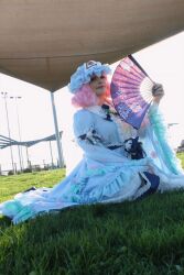 1girl absurdres cosplay cosplay_photo folding_fan grass hand_fan hat highres holding holding_fan non-web_source on_grass on_ground outdoors photo_(medium) pink_hair saigyouji_yuyuko saigyouji_yuyuko_(cosplay) short_hair sitting solo touhou
