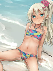 1girl akino_shuu artist_name bandeau beach bikini blonde_hair blue_eyes closed_mouth commentary_request flat_chest flower grecale_(kancolle) grecale_(swimsuit)_(kancolle) hair_flower hair_ornament kantai_collection long_hair looking_at_viewer multicolored_bikini navel ocean ponytail signature sitting solo swimsuit water